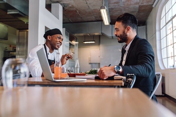 Two men sitting down having a discussion.